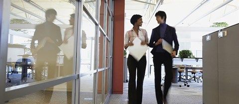 Homme et femme qui marchent dans un bureau