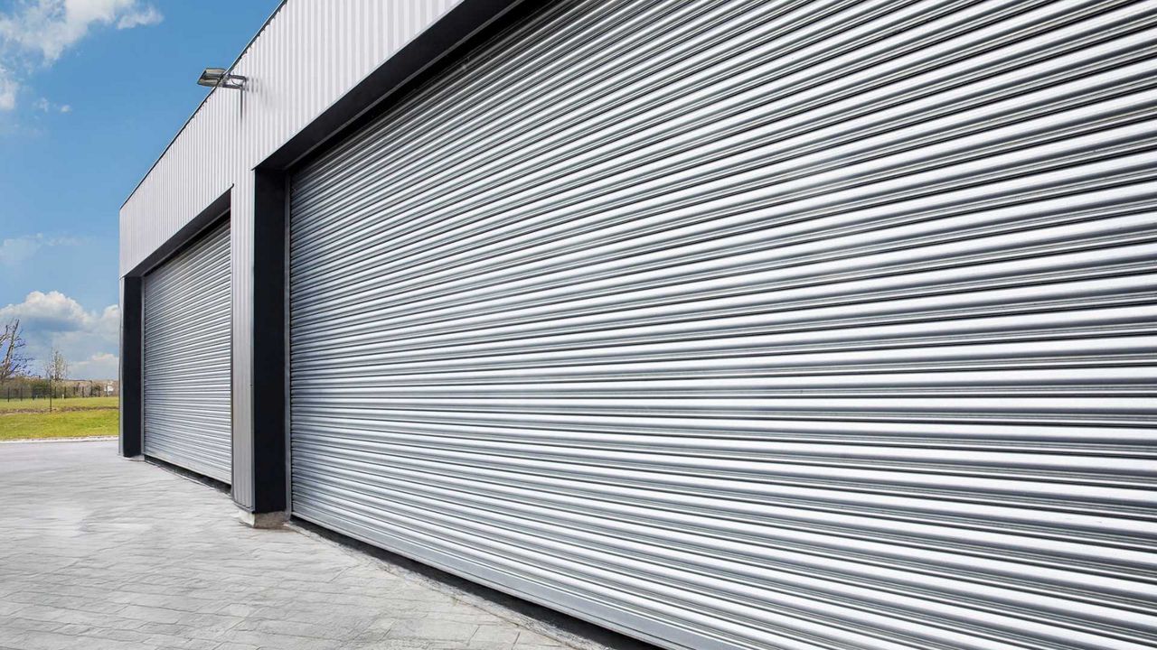 Batiment industriel gris avec plusieurs rideaux métalliques numérotés.