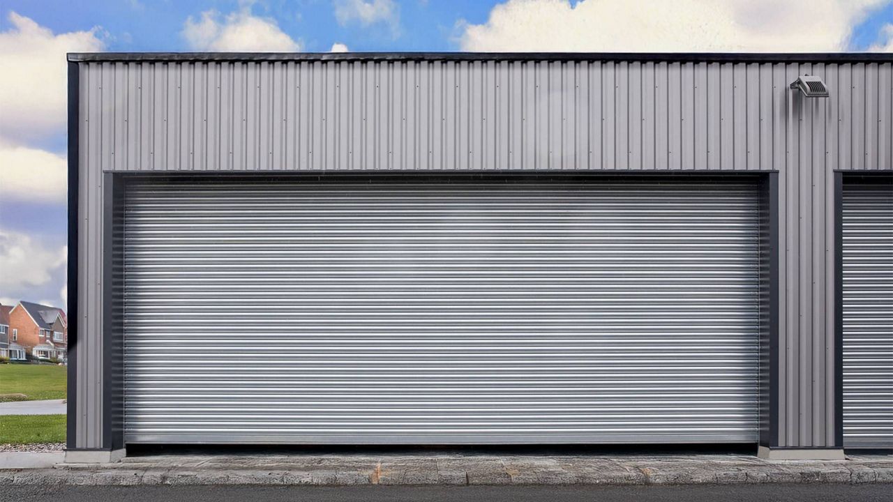 Rideau métallique simple paroi P116 de grandes dimensions installé en façade d’un bâtiment industriel, avec lames horizontales pleines.