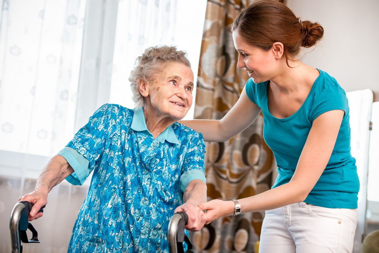 Woman helping elederly lady.