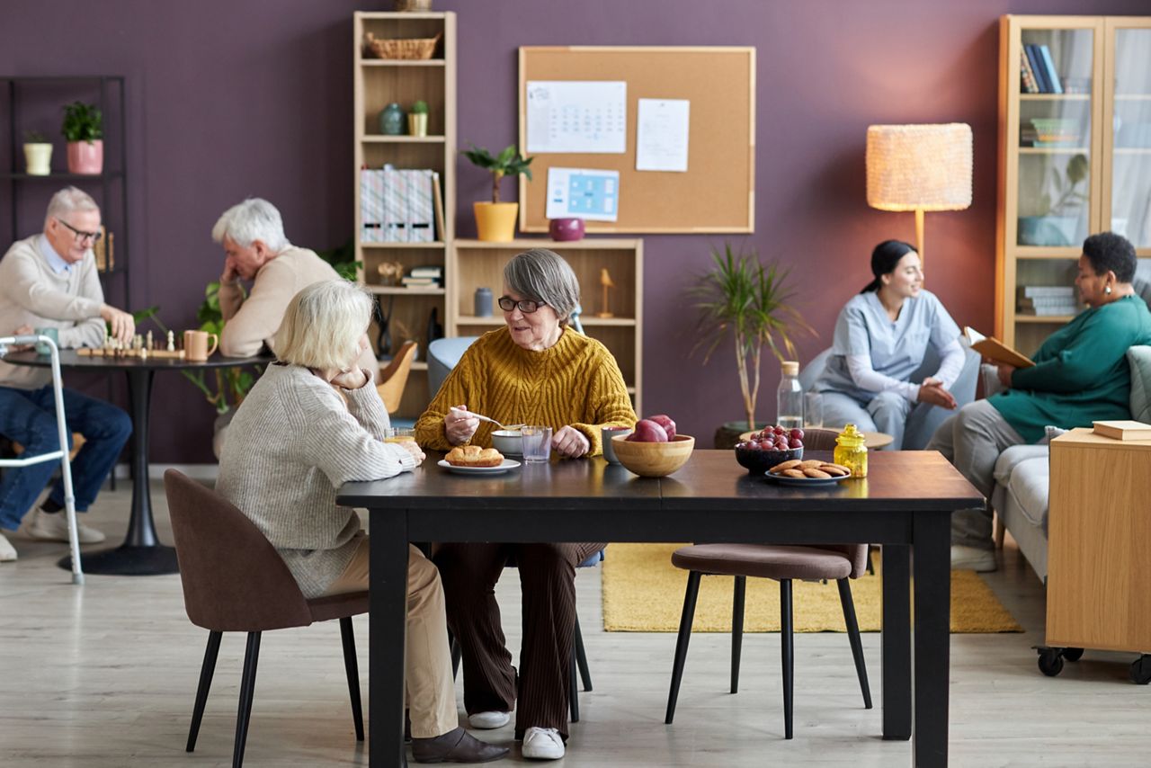 Gemeenschappelijke ruimte met ouderen die ontbijten.