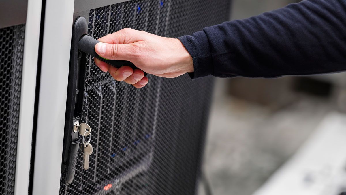 Trabalhador da TI abrindo a porta do rack do servidor com chave