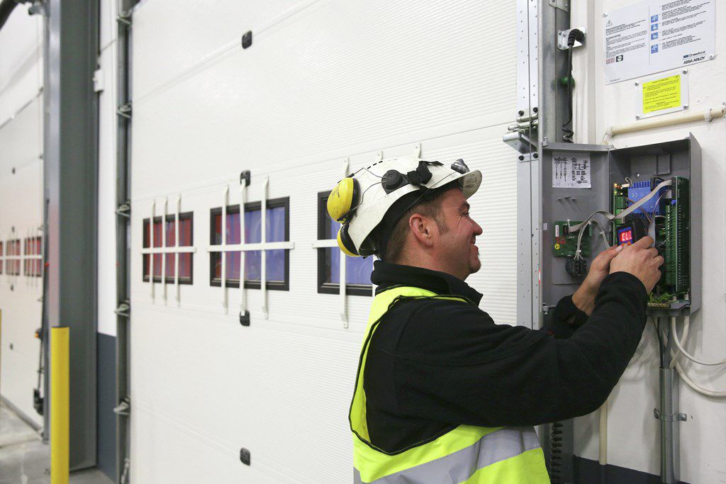 Service technician installing an industrial emergency door