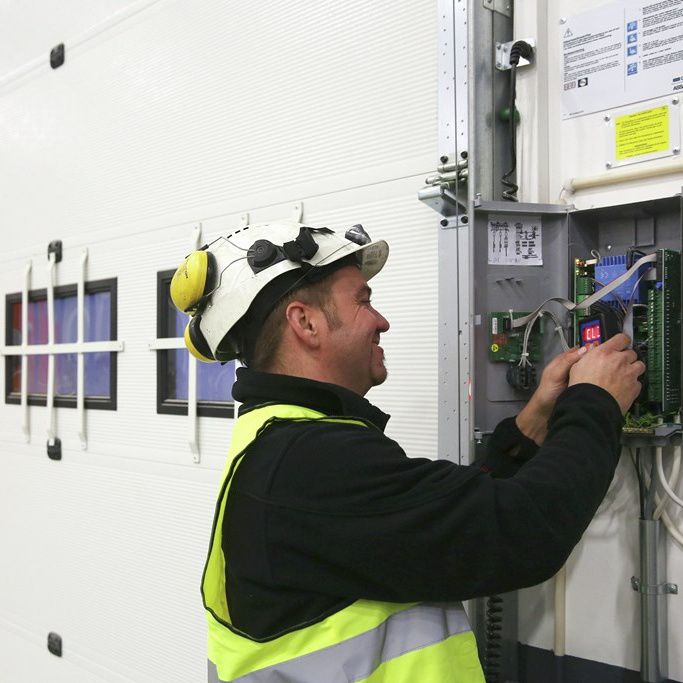 Service technician installing an industrial emergency door