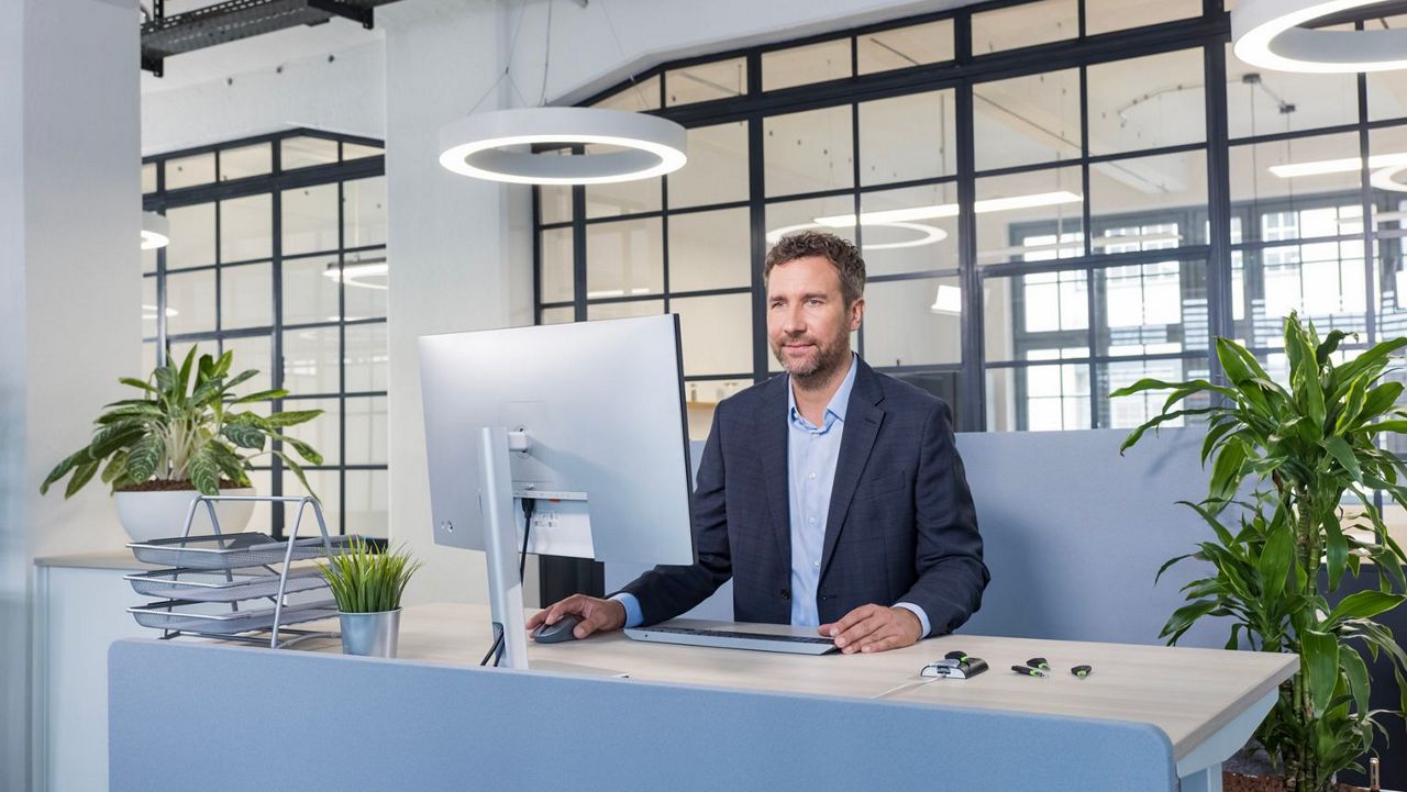 Un homme est à un bureau devant un écran d'ordinateur