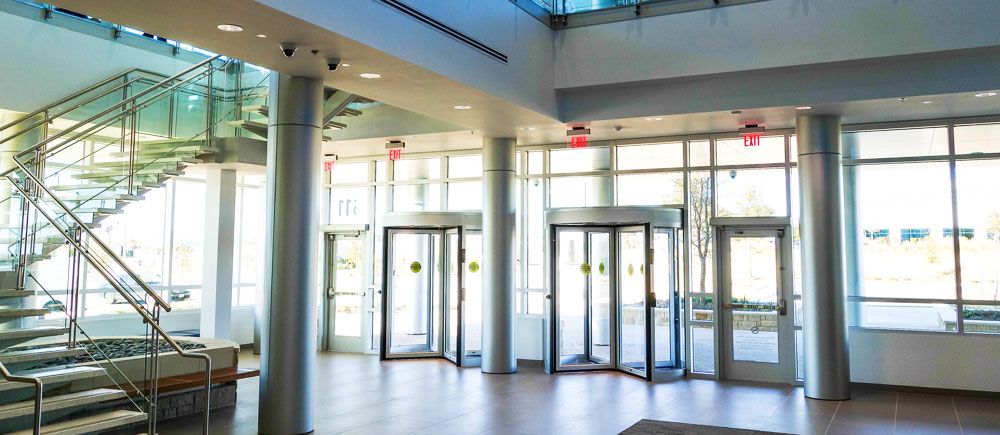 Interiérový pohled na bílé karuselové dveře ve vstupní hale