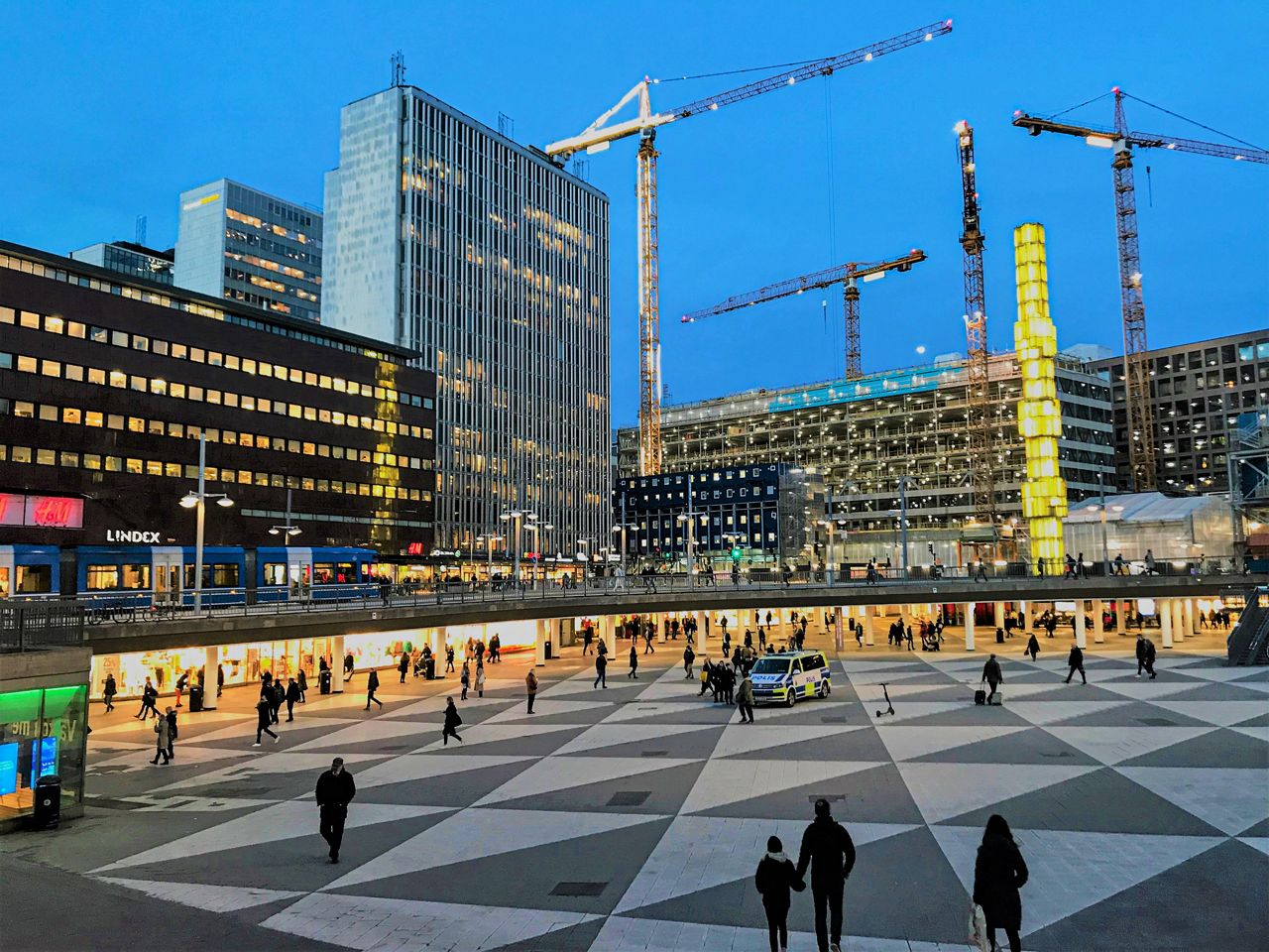 People crossing a square in the evning