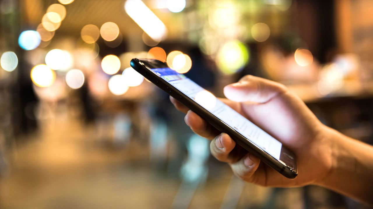 Uma mão segura um smartphone que mostra uma página web.