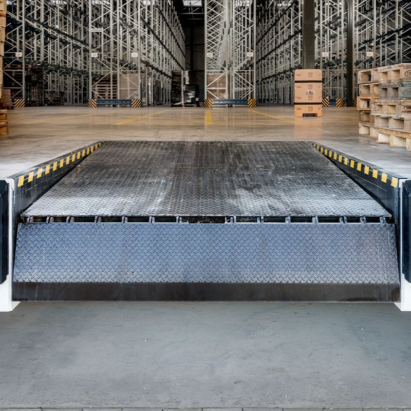 A grey dockswing with a warehouse in the background. 