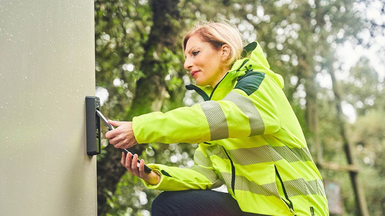 Security worker opening a telecom cabinet with Swing Handle.