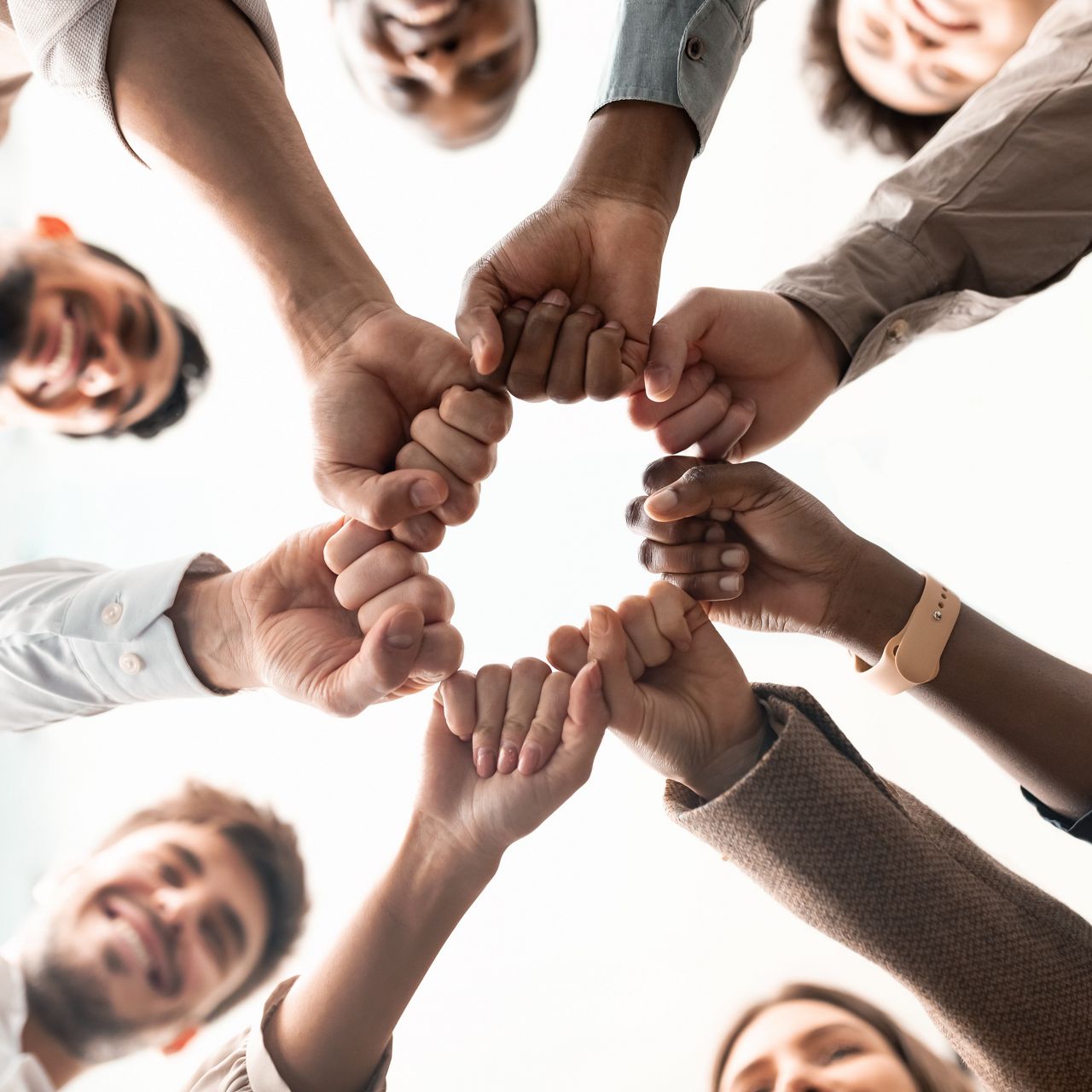 group of employees in a circle fist bumping