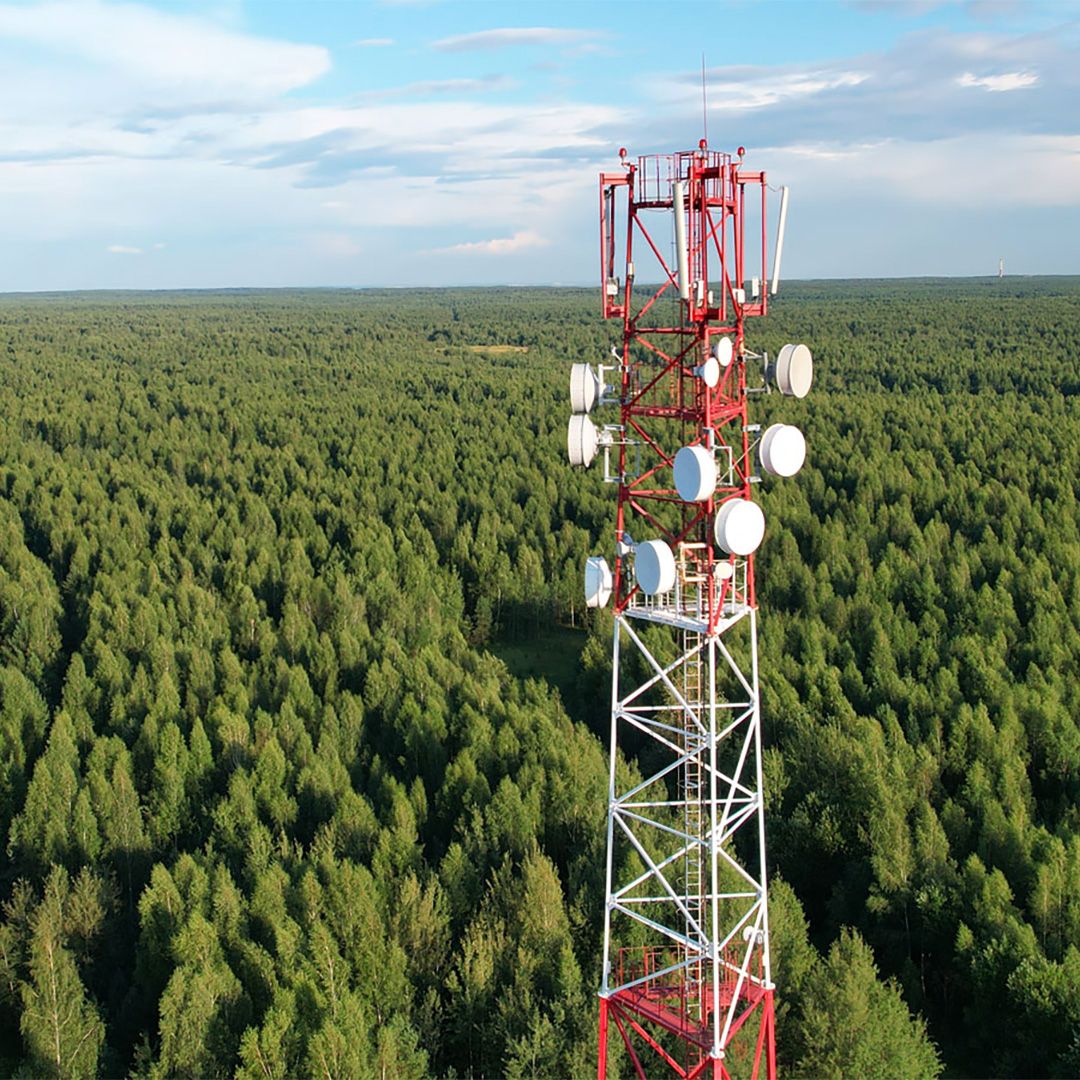 Telemast som står ute i skogen.