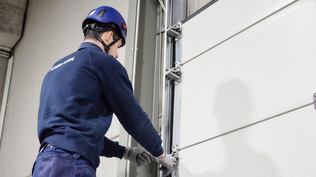 Een technieker herstelt een sectionale poort