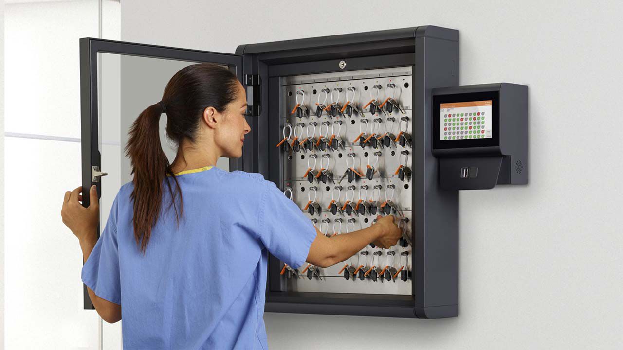 Sestrička stojí pred otvoreným kabinetom od Traky a vyťahuje si kľúč. 