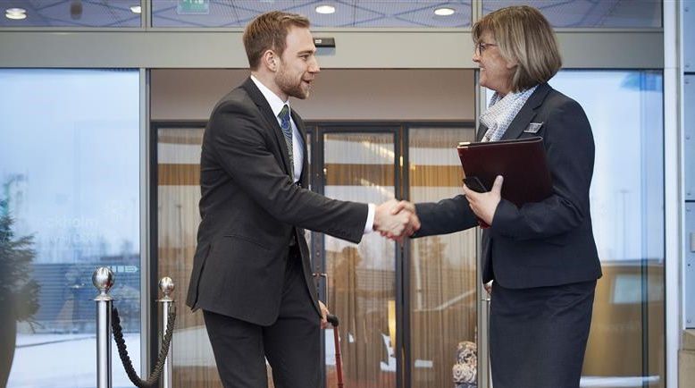 two people shaking hands outside an automatic sliding door