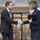 two people shaking hands outside an automatic sliding door