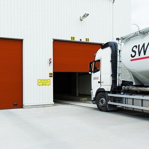 Truck driving into red industrial door
