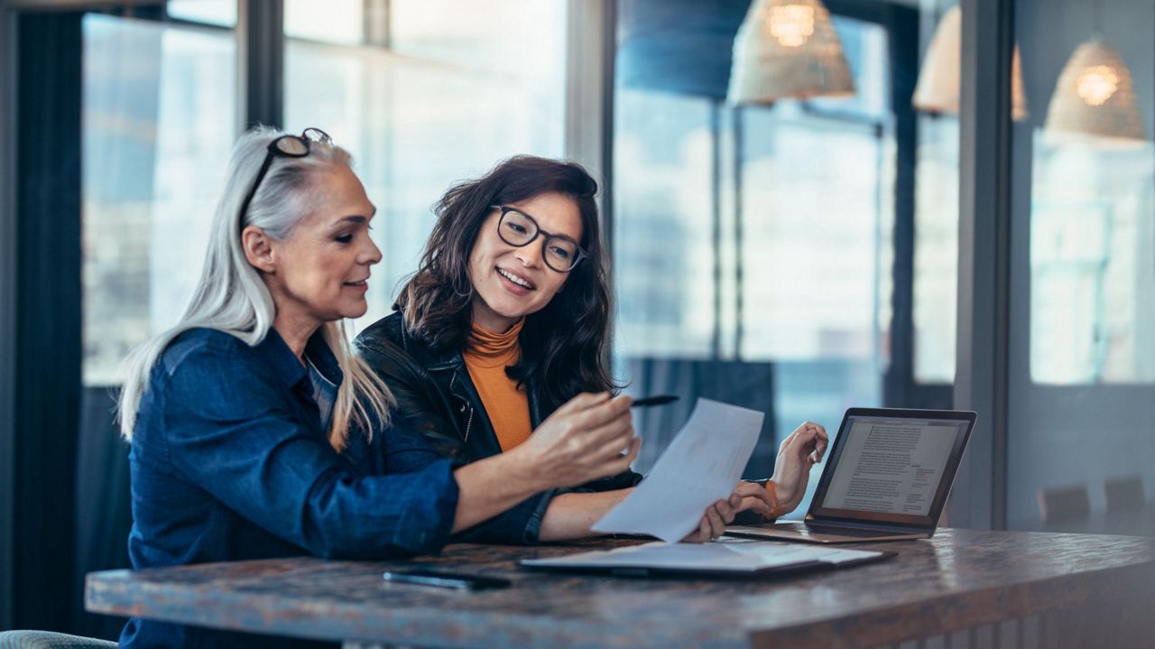 Two women talking at table.