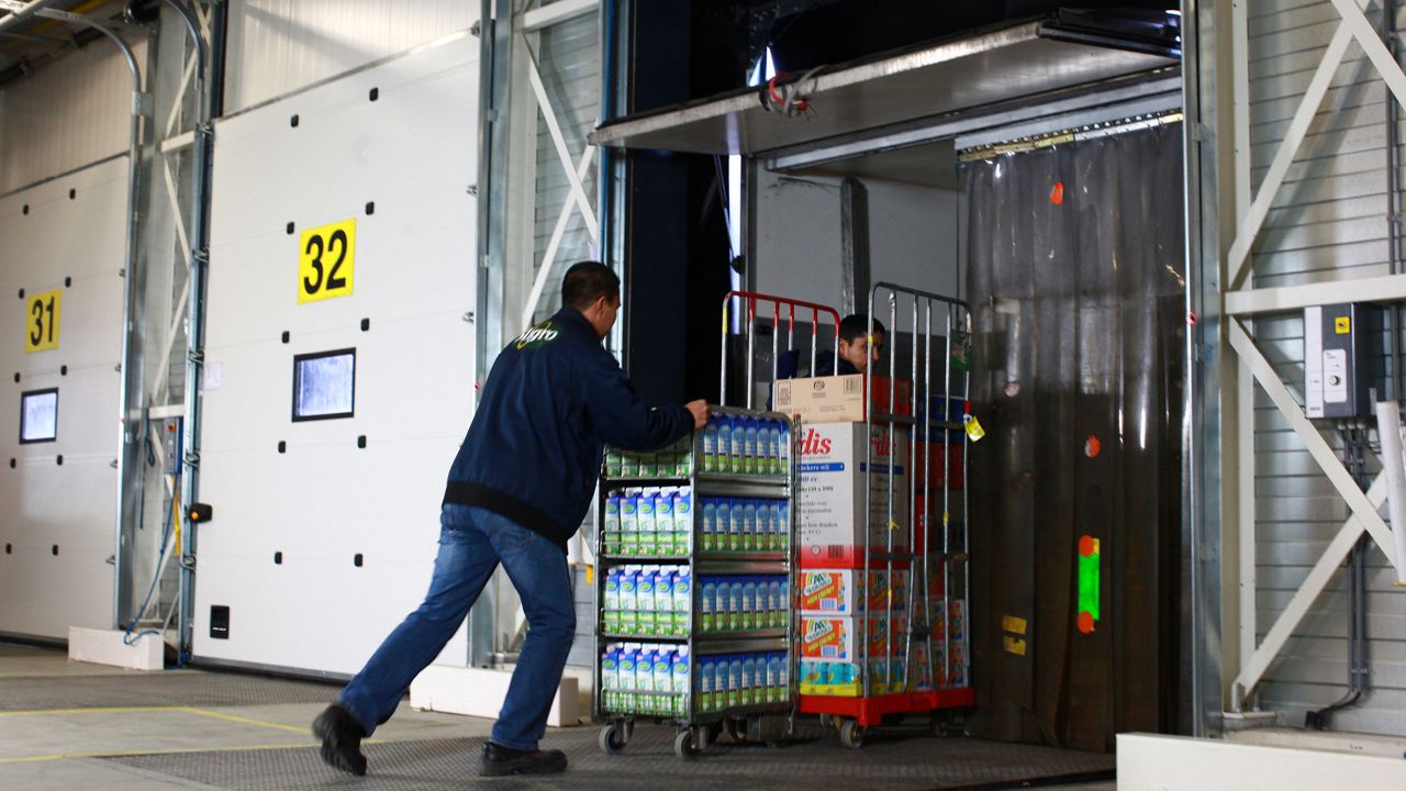 A dock leveller bridges the gap between the building and the vehicle.