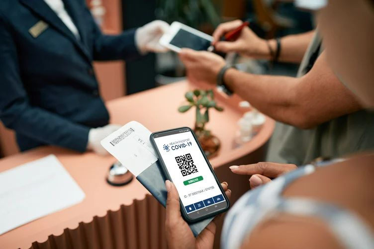 A person holding a smartphone displaying a QR code at hotel reciption.