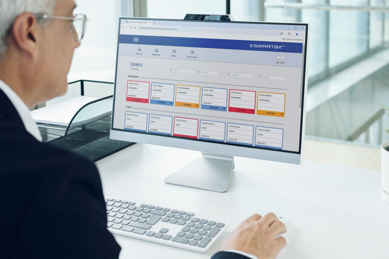 Un homme qui consulte le logiciel de gestion des utilisateurs SMARTair sur son écran d'ordinateur