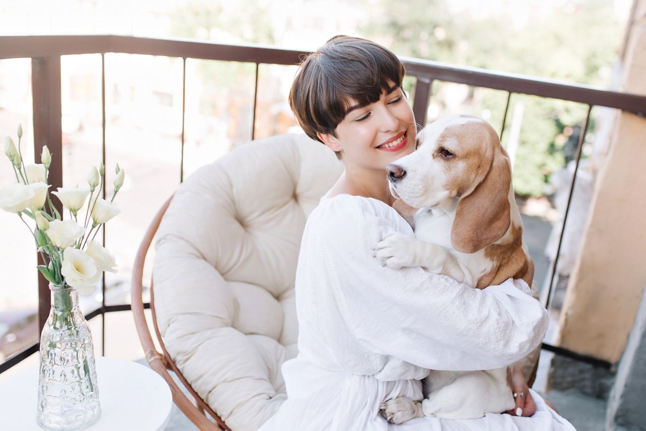 Woman with her dog sitting in her balcony