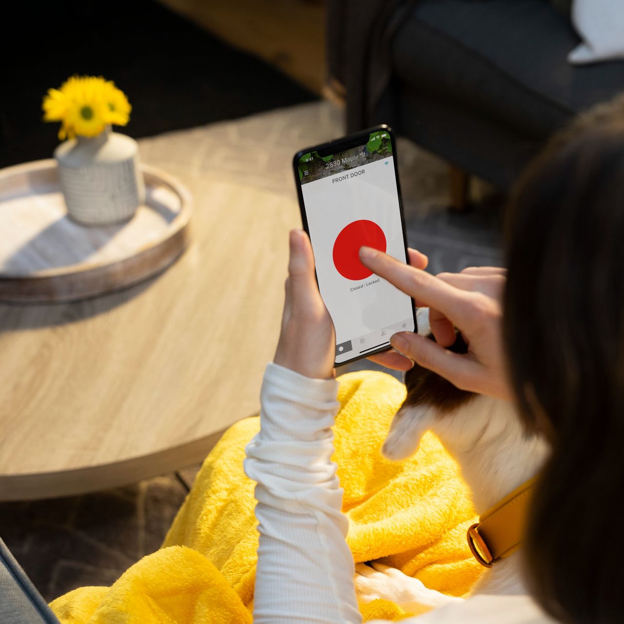 Naine kasutab Yale Connect juhtimisseadet ja Yale Access rakendust